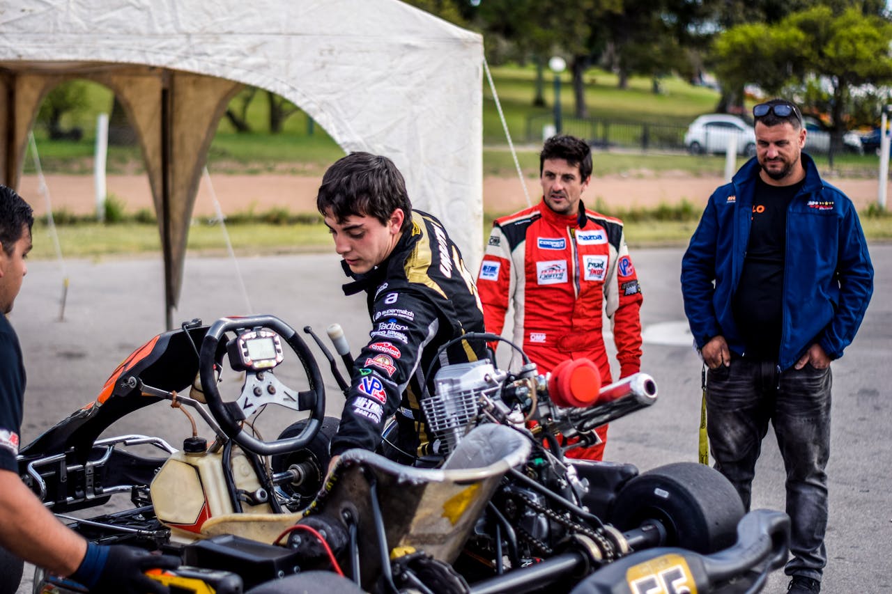 Team preparing go-kart for an outdoor race, showcasing teamwork and motorsport passion.