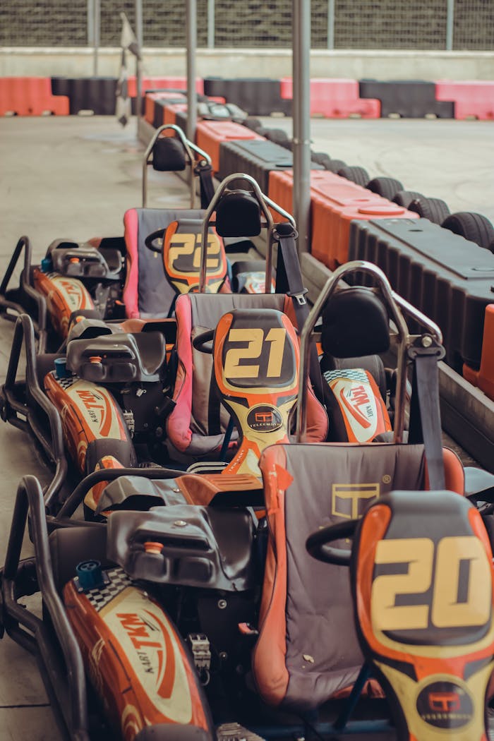 Multiple go-karts lined up at an indoor go-kart racing facility, ready for competition.